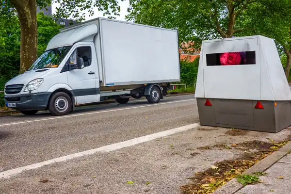 PoliScan FM1 Messsäule von VITRONIC an einer Straße neben Gerichtsakten mit Urteilen zur Verwertbarkeit der Messung